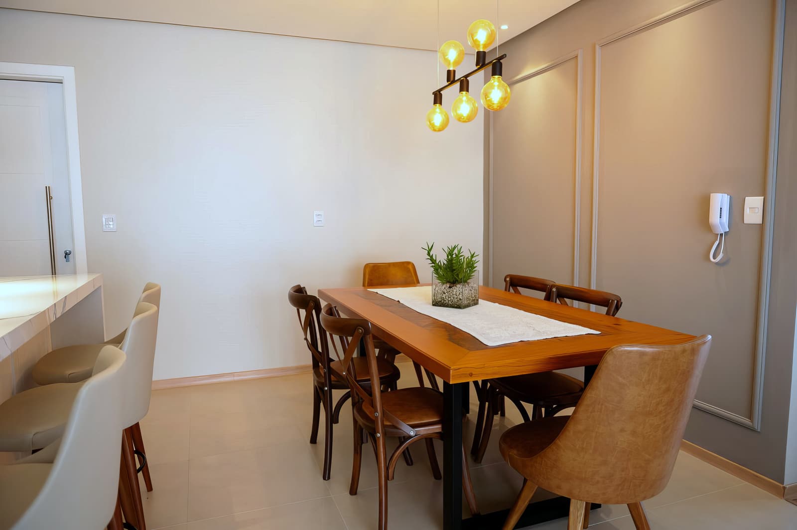 Sala de jantar com mesa de madeira maciça e luminária linear