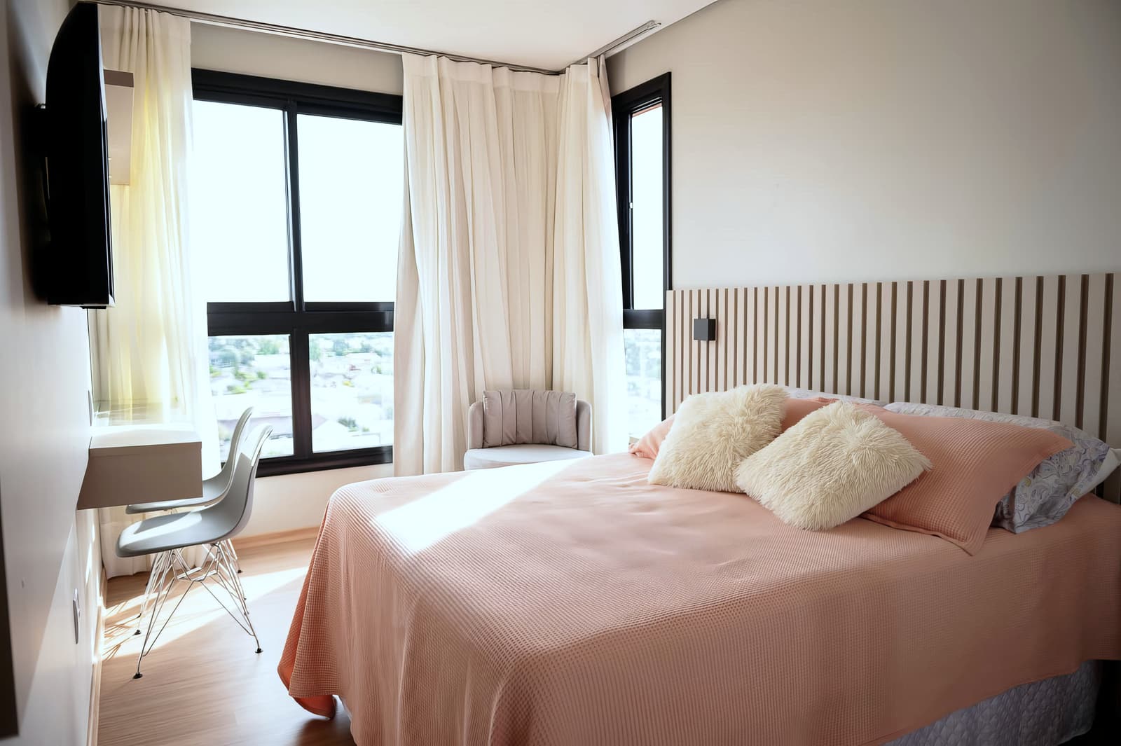 Quarto de casal com cabeceira ripada e vista da janela