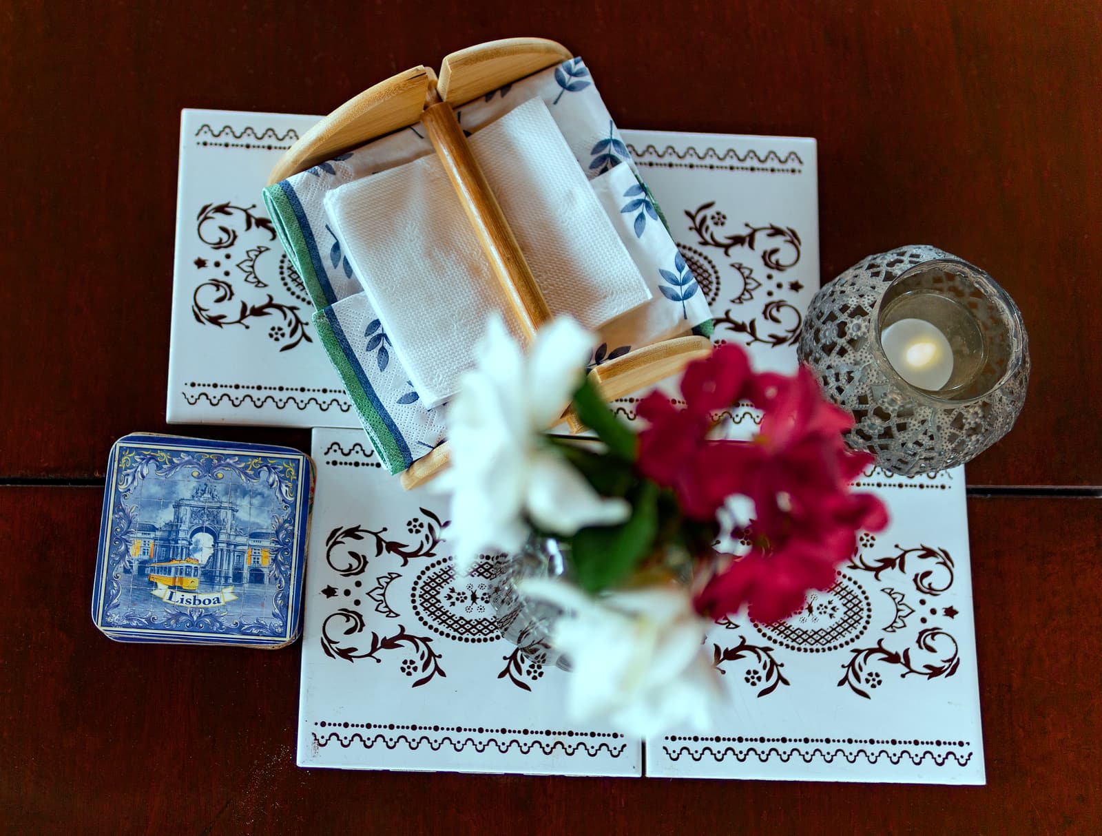 Mesa posta com toalha bordada e arranjo de flores