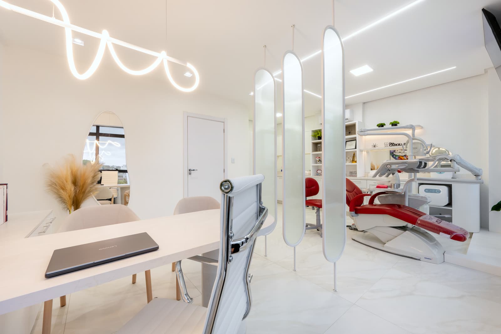 Sala clínica com janela em fita, luminária de neon e cadeira odontológica