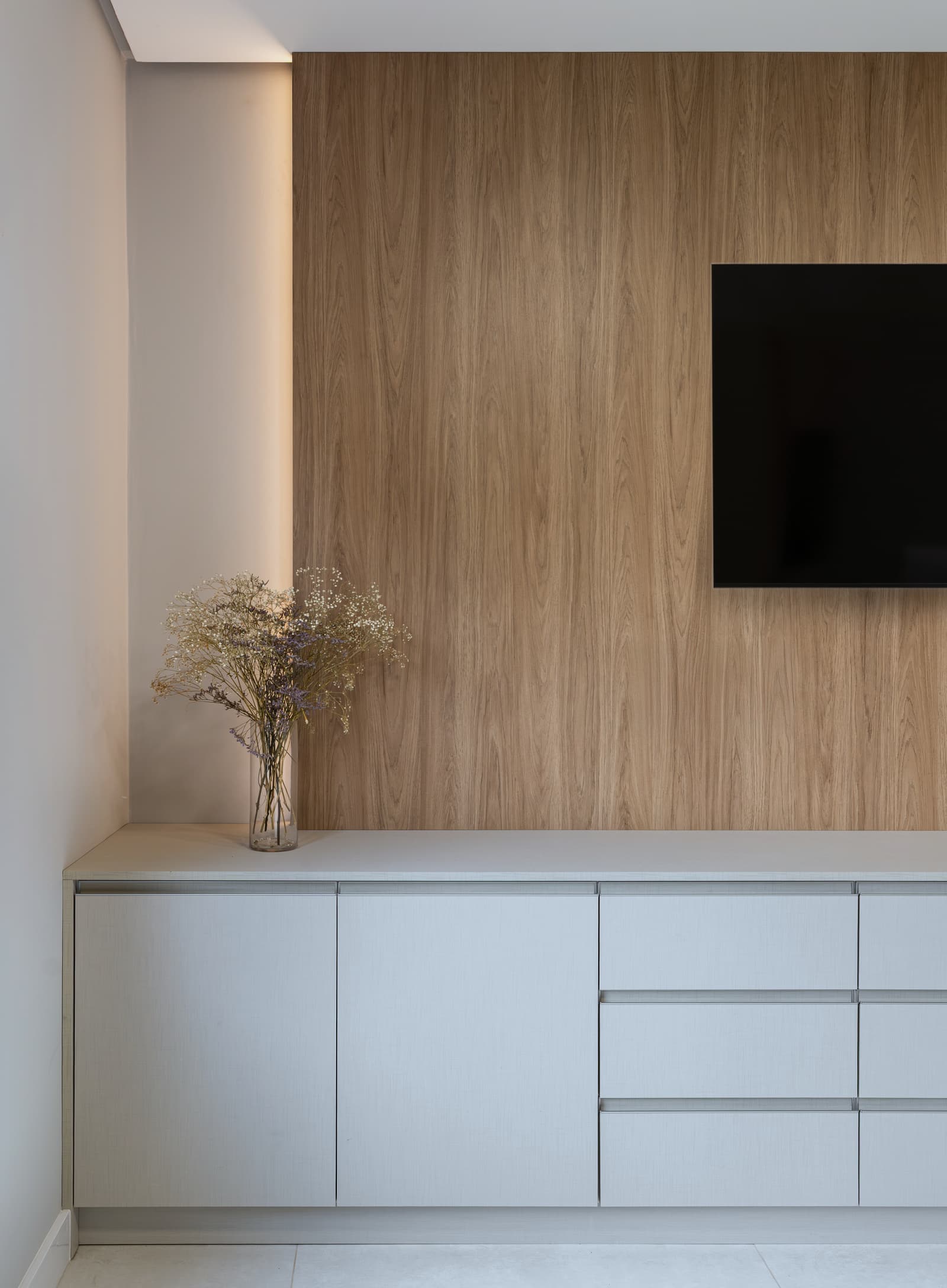 Detalhe do painel de madeira ripada que emoldura a televisão