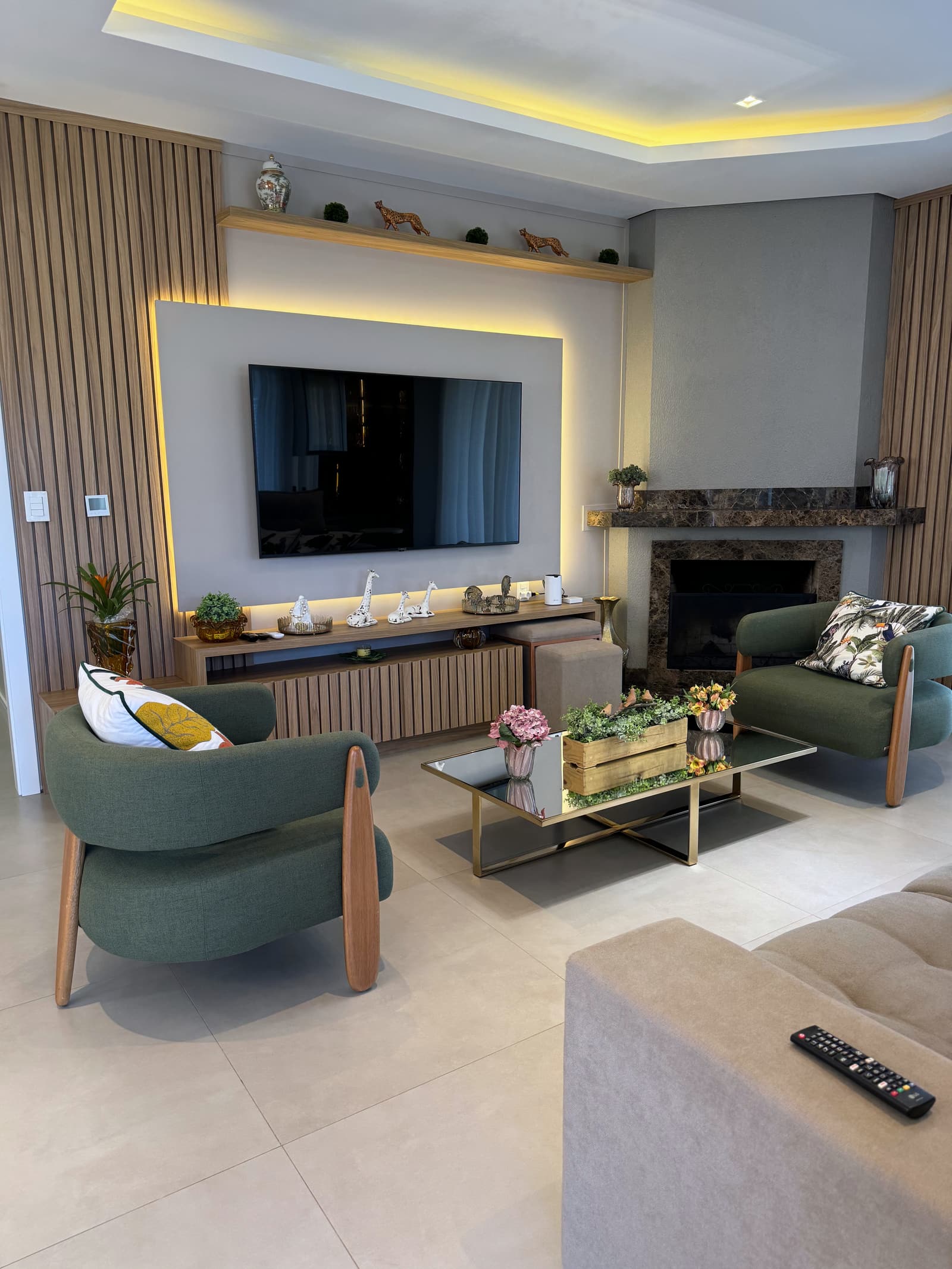 Sala de estar com lareira, sofá verde e cortina de luz filtrada